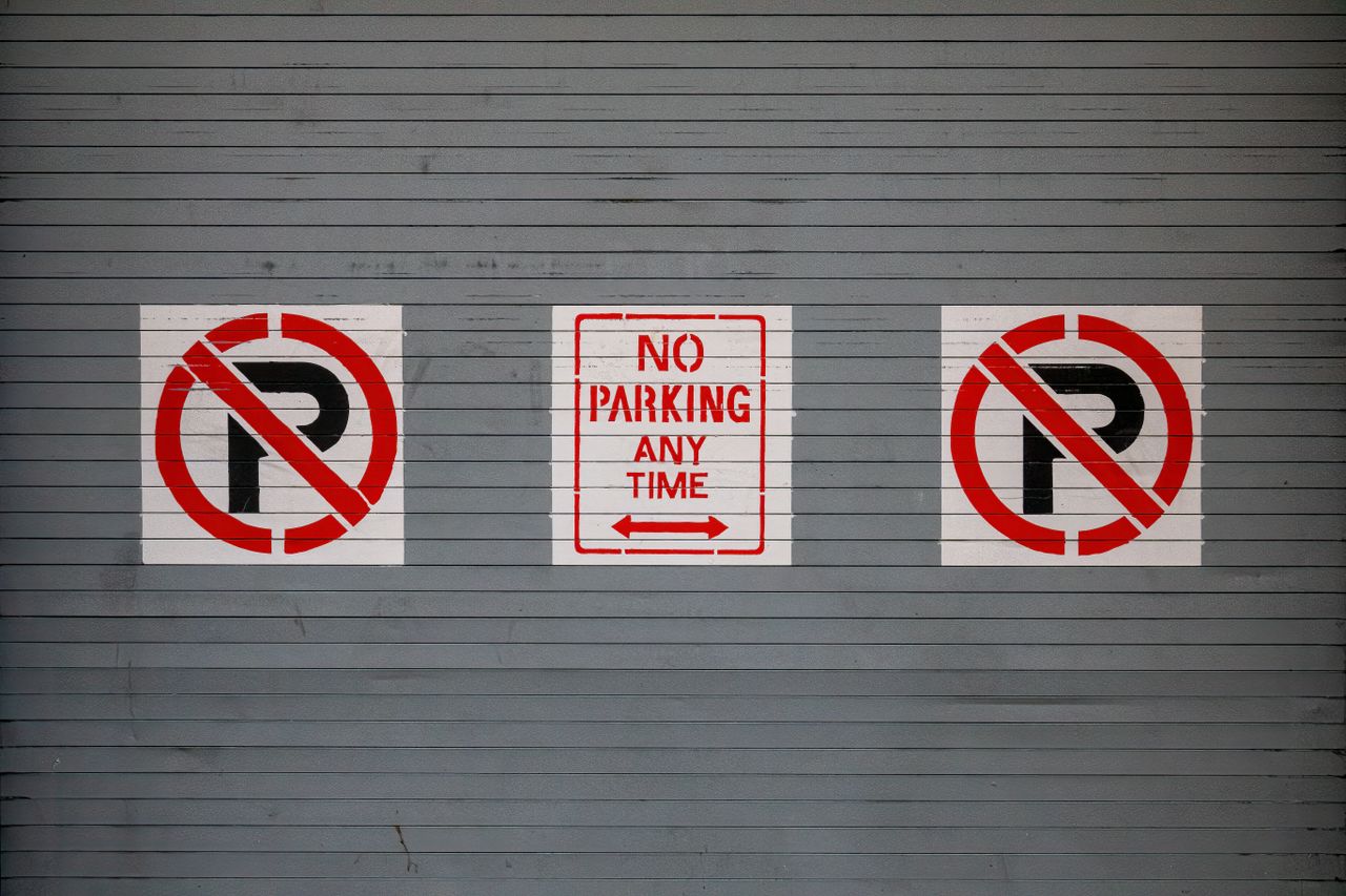 The Art of Drawing Readers In: Your attractive post title goes here Red no parking signs on a gray wall in San Francisco, California.