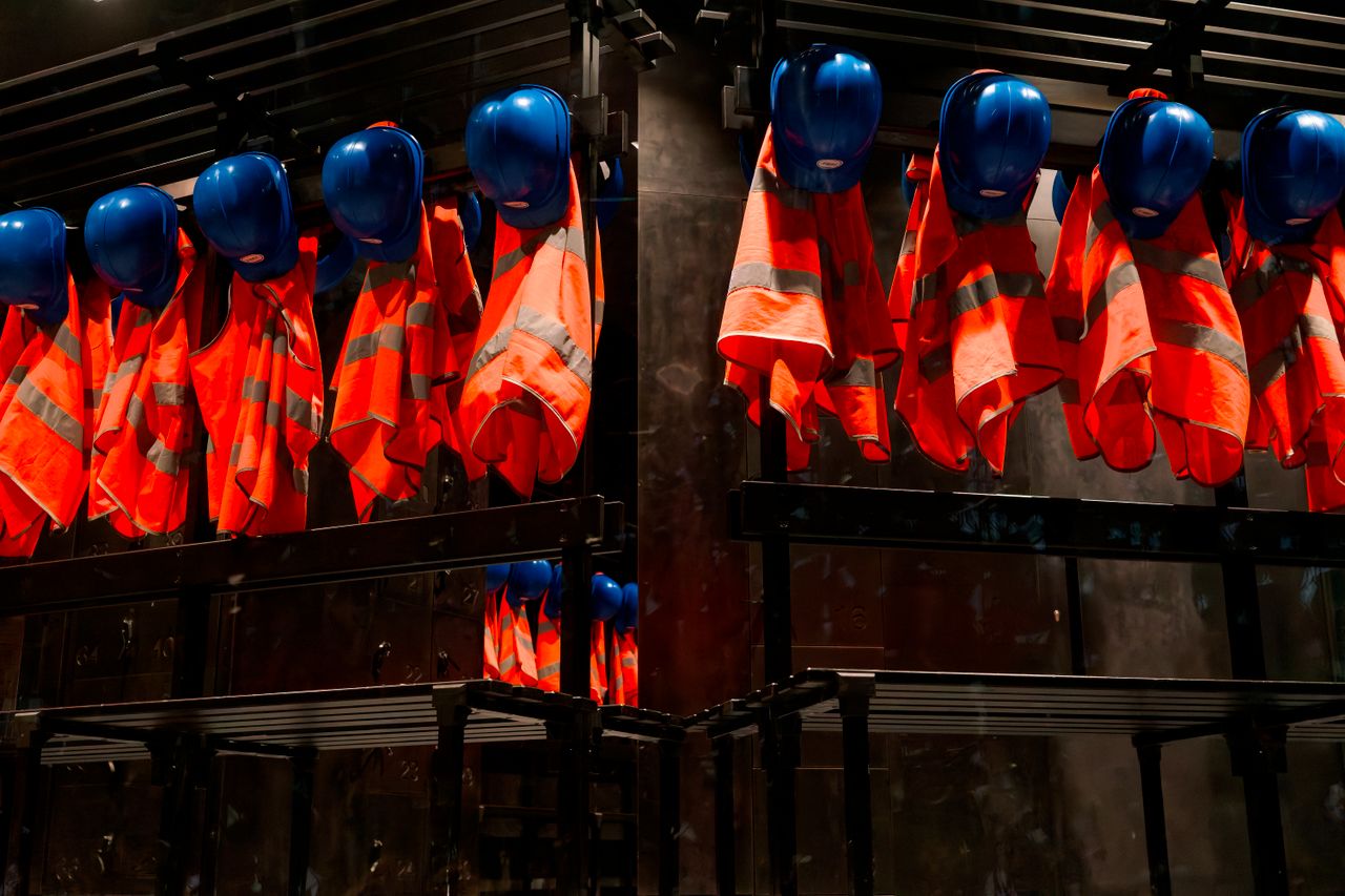 Crafting Captivating Headlines: Your awesome post title goes here Row of orange safety vests and blue helmets hanging in industrial setting